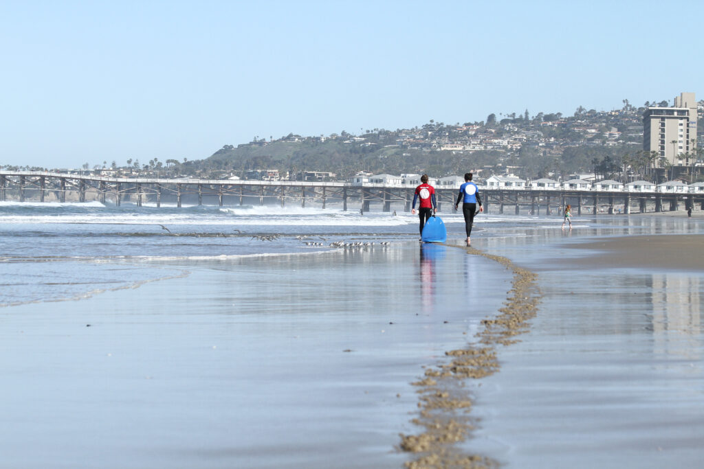 Two surfers walking with their surfboards at Pacific Beach